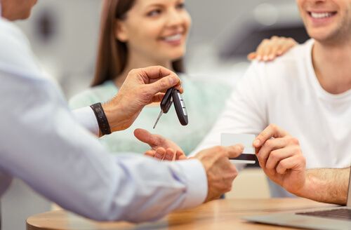 A couple receiving car keys after a notarized sale