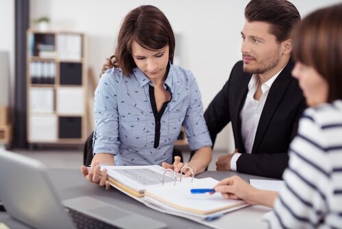 A realtor and clients reviewing closing documents with a notary